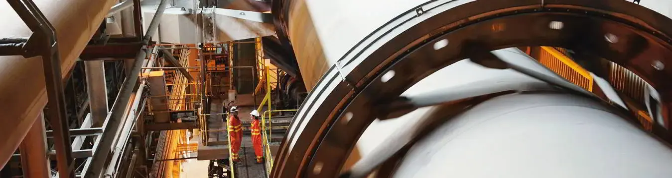 Blick von oben auf zwei Bauarbeiter in einem Metallwerk