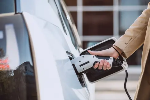 femme-chargeant-voiture-electrique-station-essence-electrique